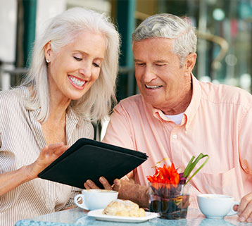 A man and woman looking at an ipad.