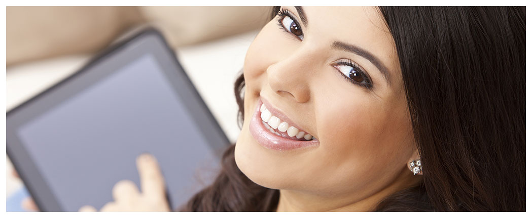 Smiling woman holding a digital tablet.