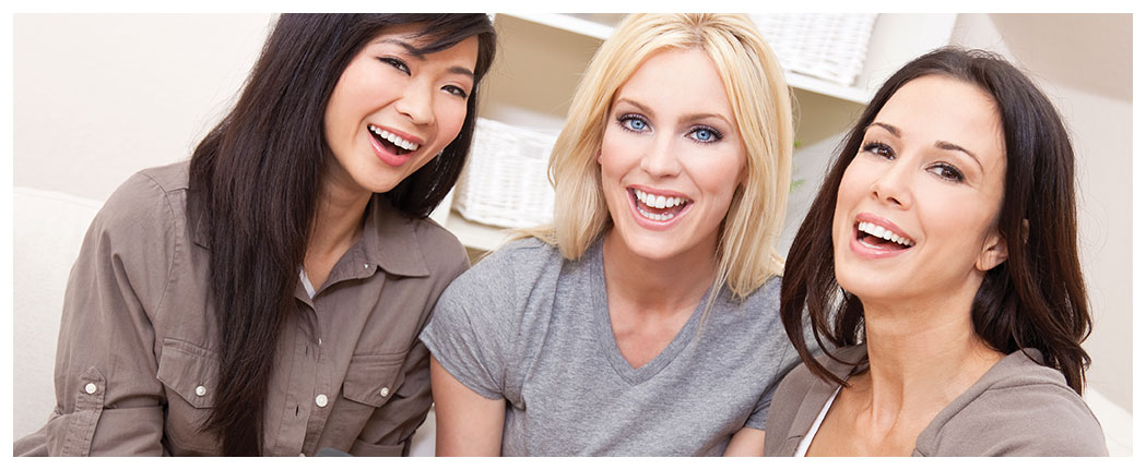 Three smiling women friends sitting together
