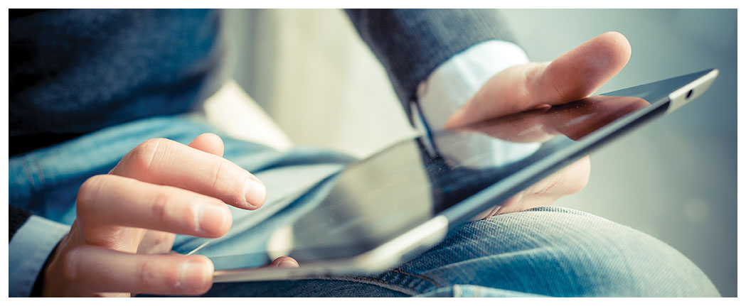 Person using a tablet on lap.