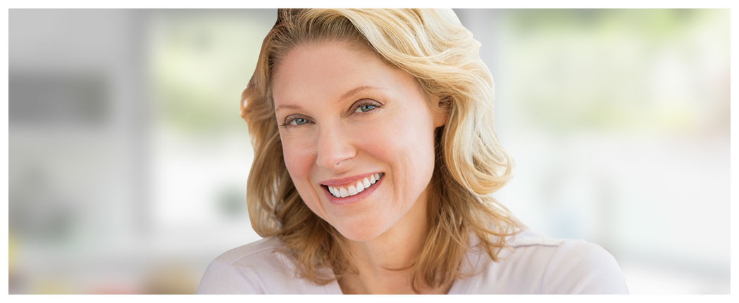 Smiling woman with blonde hair indoors.