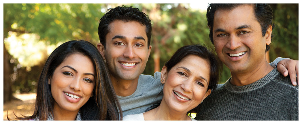 Smiling family posing outdoors together.